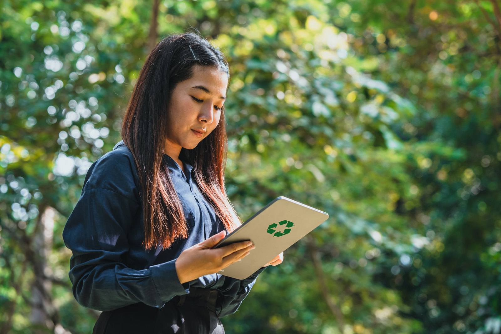 Responsable RSE consultant son reporting sur tablette en pleine nature